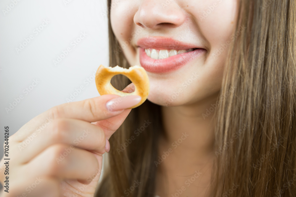 young beautiful girl eating bagels, close-up, crop photo.Attractive brunette sexy woman eating a delicious donut. young beautiful girl eating bagels, close-up, crop photo.Attractive brunette sexy woman eating a delicious donut.