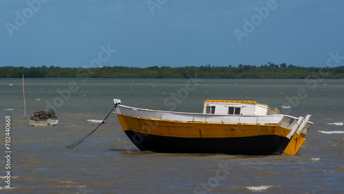 Fishing boat anchored on the beach waiting to go out to sea. photo