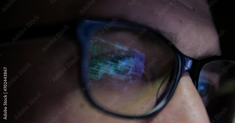 Close-up of eyes in glasses of businessman programmer. Work behind a monitor or laptop to create artificial intelligence. finance on the Internet. Hacker and network security. Close-up of eyes in glasses of businessman programmer. Work behind a monitor or laptop to create artificial intelligence. finance on the Internet. Hacker and network security.
