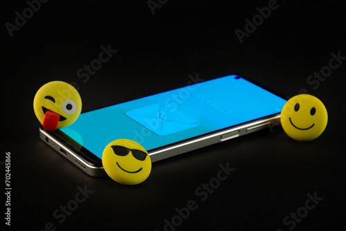 Mobile phone with smiley faces and emojis.