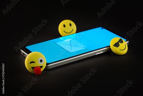 Mobile phone with smiley faces and emojis.