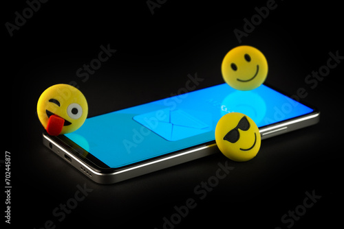 Mobile phone with smiley faces and emojis.