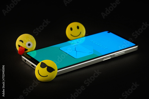 Mobile phone with smiley faces and emojis. photo