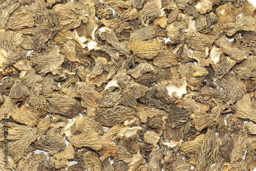 Many dried Verpa bohemica mushrooms lie on the table, laid out in a thin layer. The first spring mushrooms are ready for use for cooking. High quality photo photo