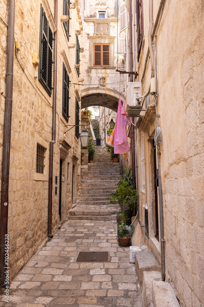The medieval city of Dubrovnik, Dalmatia, Croatia. Narrow street with a staircase and an arch.