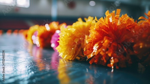 Colorful cheerleading pom-poms on a gym floor photo