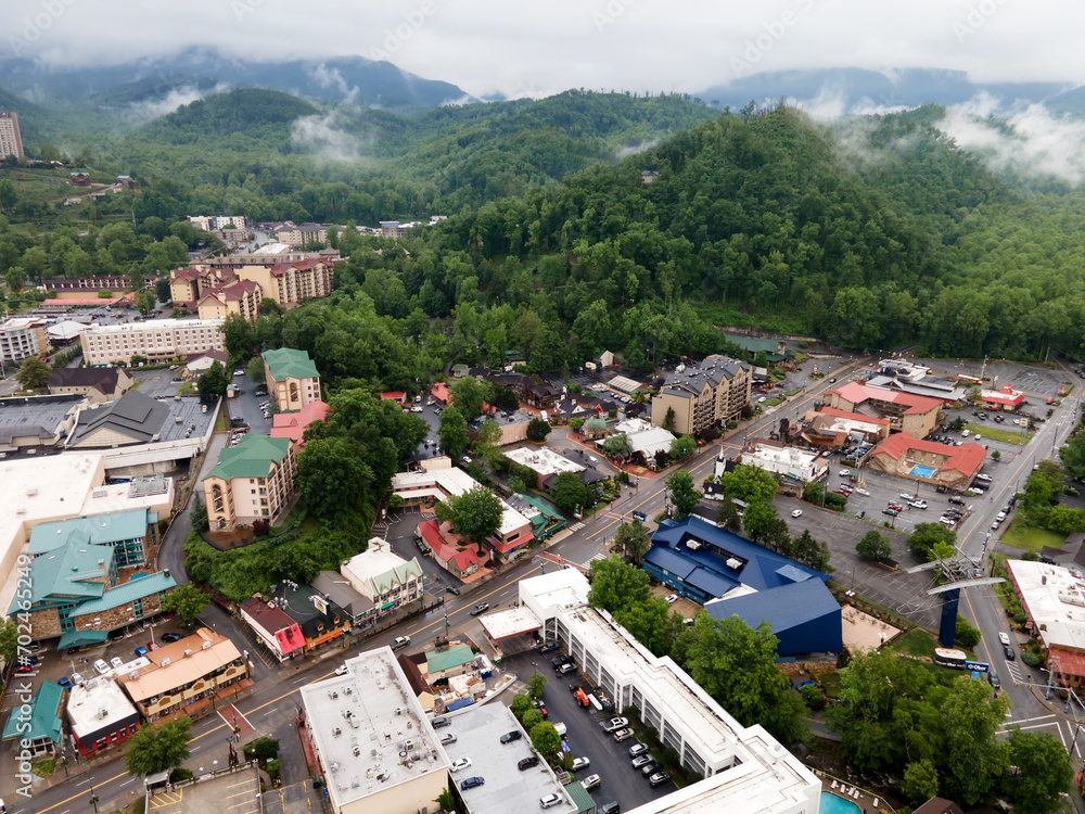 city of Gatlinburg in Tennessee and the Great Smoky Mountains from a bird's eye view, a tourist mecca with hotels, parking and shops.