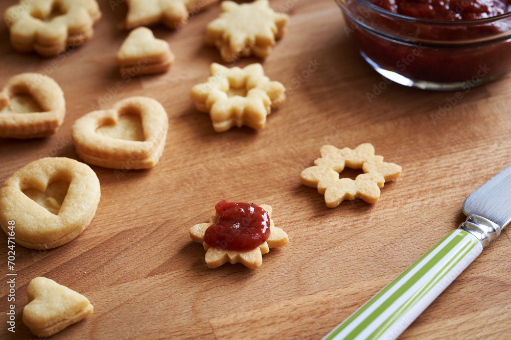Filling homemade Linzer Christmas cookies with red jam Filling homemade Linzer Christmas cookies with red jam