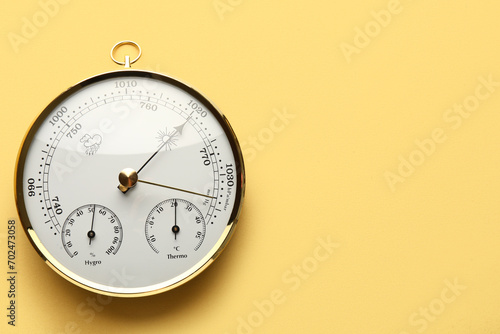 Aneroid barometer on yellow background photo