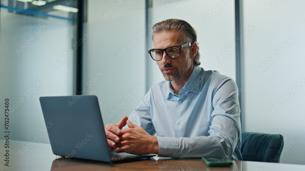 Serious boss video chatting laptop closeup. Confident man having web video call Serious boss video chatting laptop closeup. Confident man having web video call