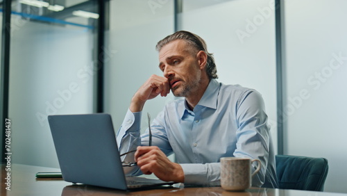 Worried ceo sitting workplace closeup. Stressed businessman getting bad news photo