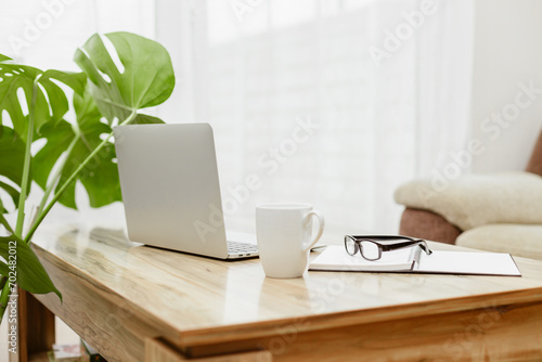 Wallpaper Mural The laptop is on the table next to glasses, a notepad and a cup of coffee. A workspace at home. Distant work Torontodigital.ca
