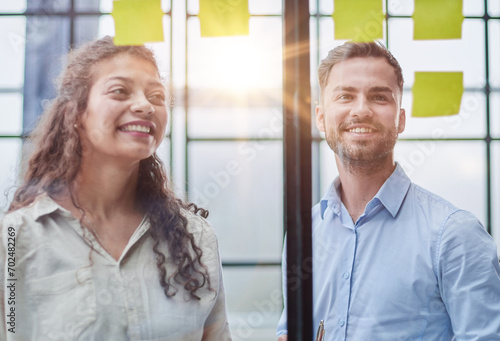 Business people talking in the hallway of the modern office building with employees working behind glass partitions. Work in a large business corporation