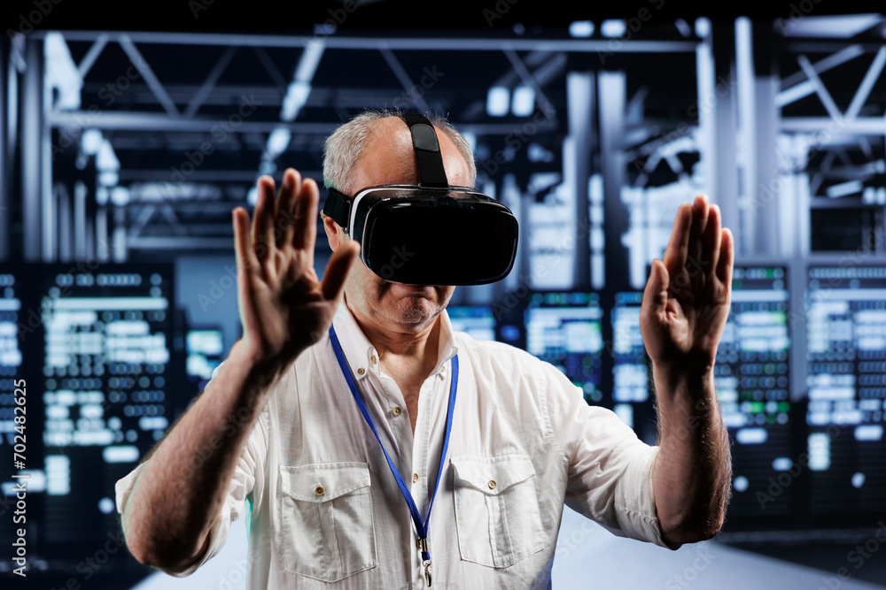 Elderly adept technician immersed in virtual reality at data center, doing infrastructure maintenance. Specialist using VR headset to optimize server clusters system performance Elderly adept technician immersed in virtual reality at data center, doing infrastructure maintenance. Specialist using VR headset to optimize server clusters system performance