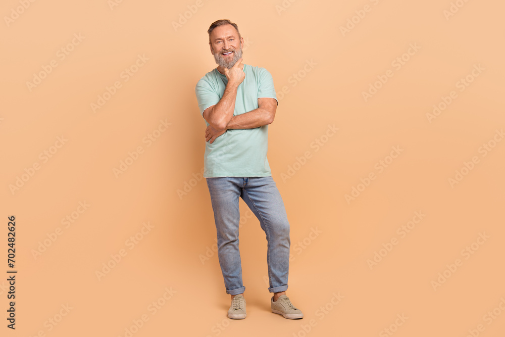 Full size portrait of minded creative person hand touch chin contemplate empty space isolated on beige color background Full size portrait of minded creative person hand touch chin contemplate empty space isolated on beige color background