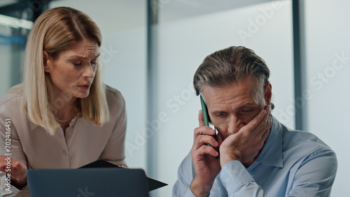 Nervous businessman talking smartphone office closeup. Couple working together