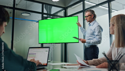 Businessman making chromakey presentation office. Coach pointing at green screen