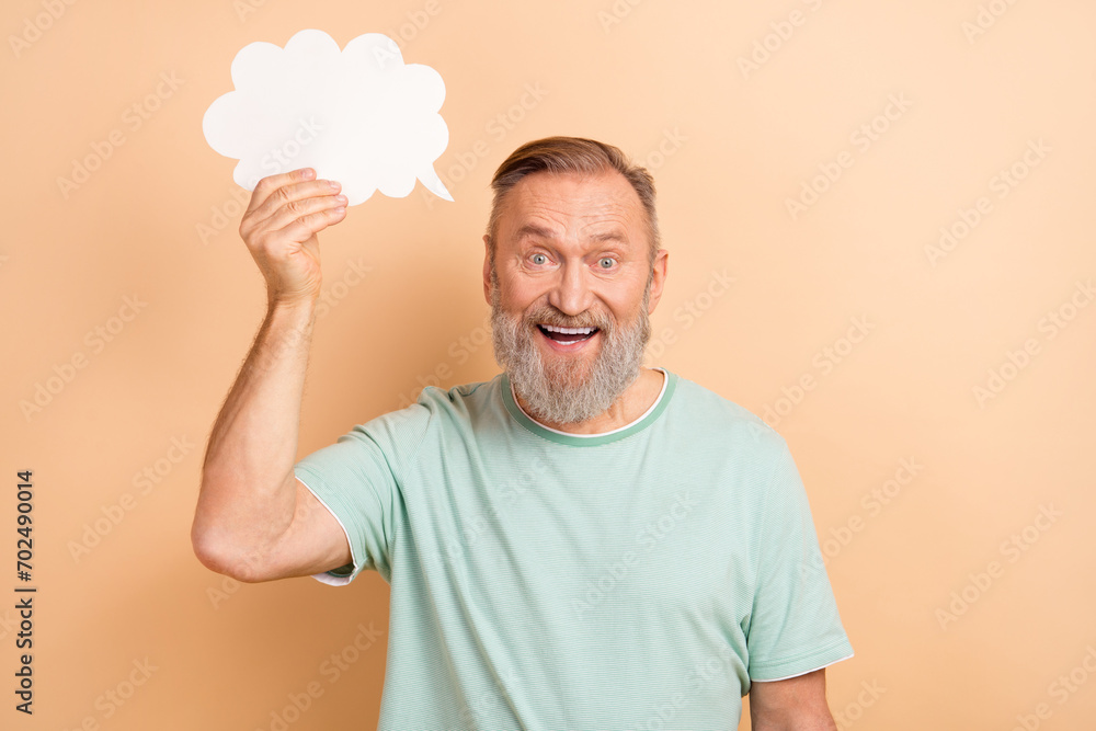 Photo of positive excited senior man wearing stylish clothes announcing news empty space isolated on beige color background Photo of positive excited senior man wearing stylish clothes announcing news empty space isolated on beige color background