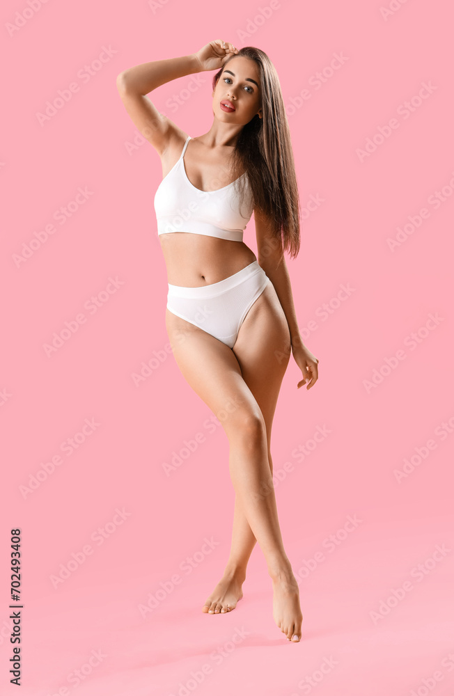 Naklejka premium Beautiful woman in underwear on pink background