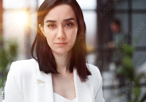 Beautiful young lady in white jacket smiling at camera