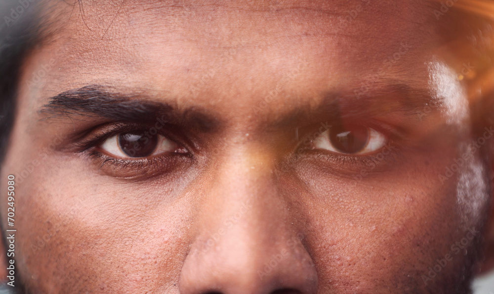 Naklejka premium Close-up of the face and eyes of an Indian man in an emotional pose, eyes open