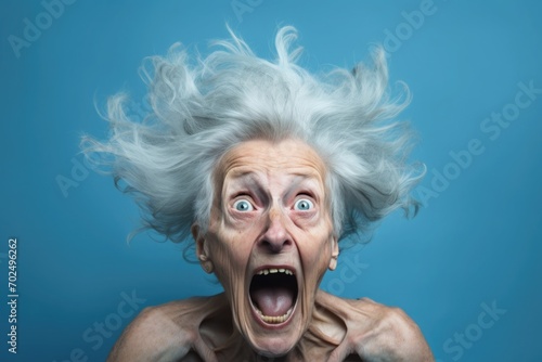 Upset old, adult woman, female in blue t shirt screaming and crying with opened mouth and closed eyes against © Svetlana