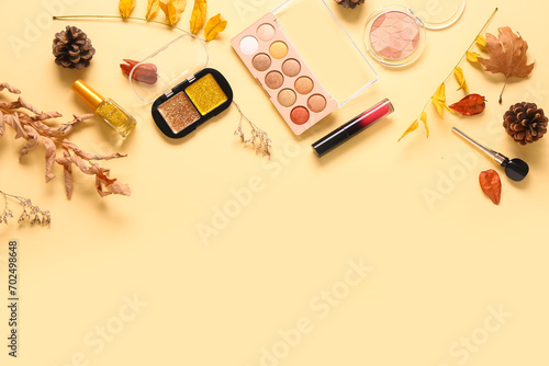 Beautiful autumn composition with different makeup products on beige background