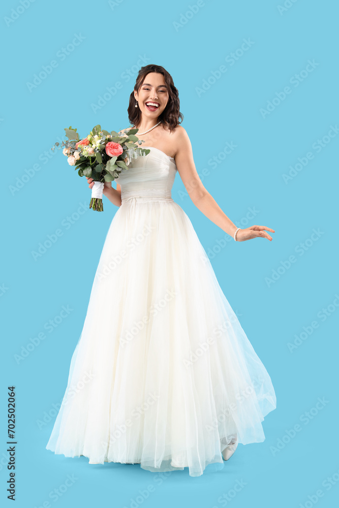 Beautiful bride with wedding bouquet on blue background