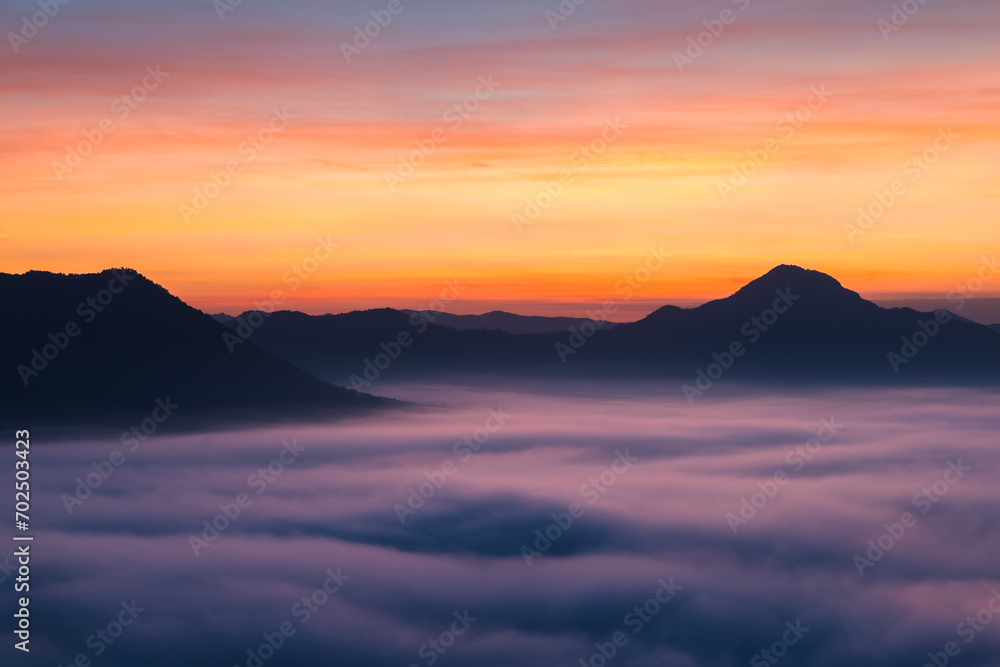 Thick fog covered the mountainside in the morning, with the beautiful twilight light. Landscape aerial view of Phu Thok, Chiang Khan, Thailand