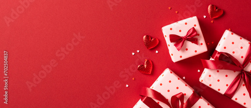 Valentine's day banner template. Flat lay gift boxes with hearts on red background. Top view, copy space.