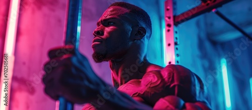 Muscular man powerlifting in neon-lit cross-training gym. photo