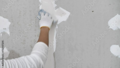 Plasterwork and wall painting preparation. close up hand of craftsman applying filling drywall patch.