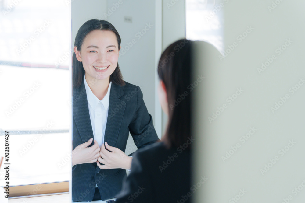 洗面所の鏡を見る若いビジネスウーマン(美容) 洗面所の鏡を見る若いビジネスウーマン(美容)