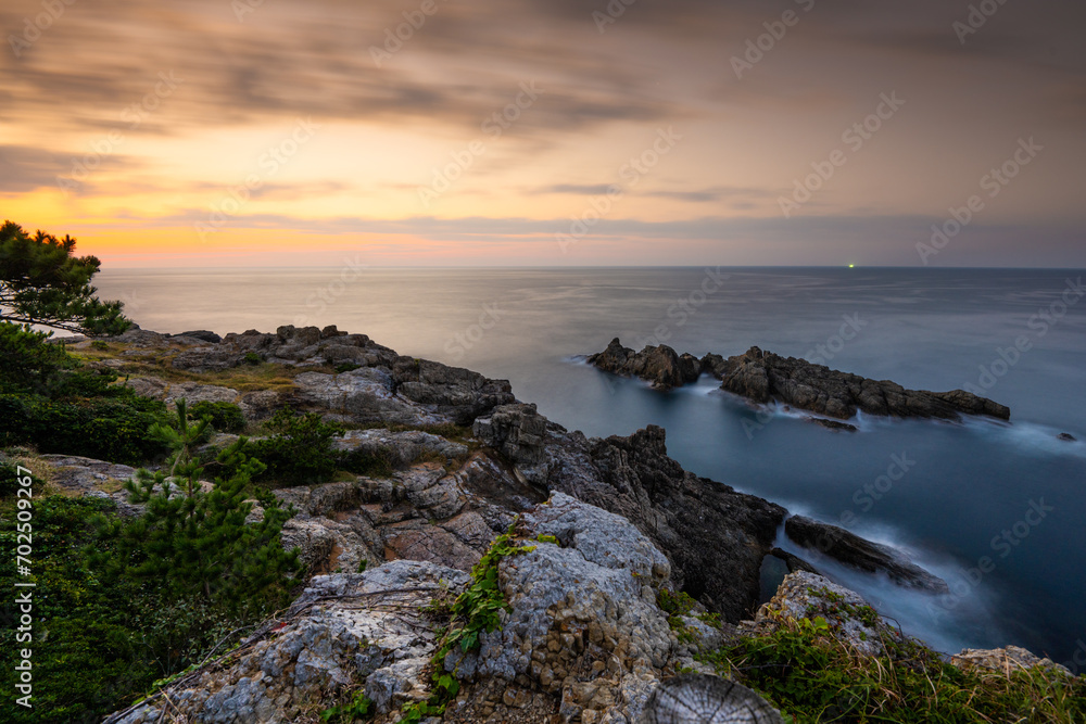 Coastal rocks at sunset seascape