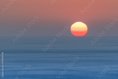 Fototapeta Naklejka Na Ścianę i Meble -  Sun setting over blue ocean