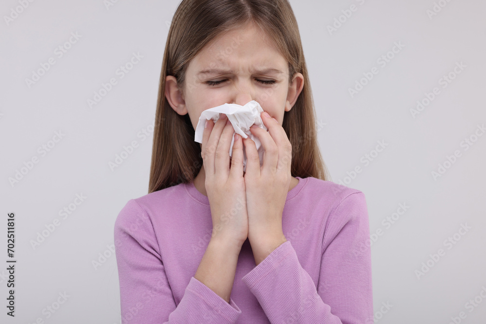 Sick girl with tissue coughing on light background Sick girl with tissue coughing on light background