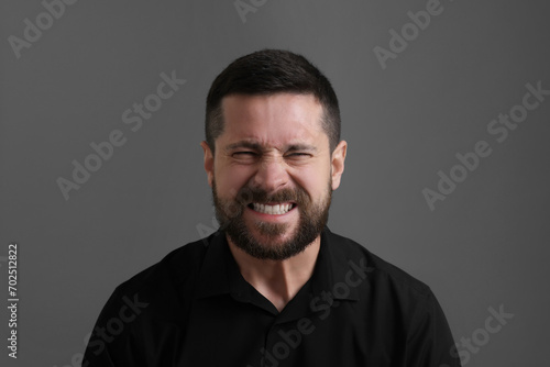 Personality concept. Angry man on grey background