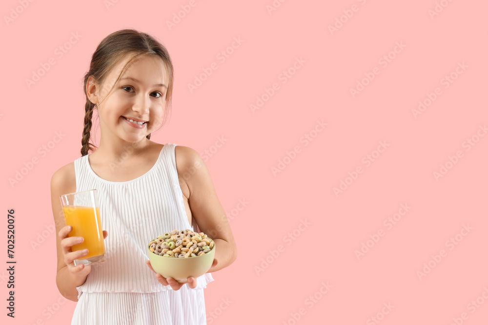 Cute little girl with bowl of cereal rings and orange juice on pink background Cute little girl with bowl of cereal rings and orange juice on pink background