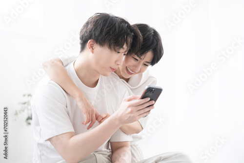 Couple, Cellphone, Holding, Front View, Looking At Camera, Backlit, Close Couple, Together, Man And Woman, Couple, Newlywed, Cute, Living Room, People, Lifestyle, Two People, Smartphone, Smiling, Fami
