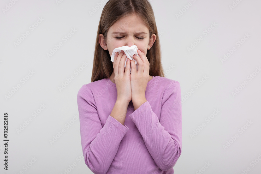 Sick girl with tissue coughing on light background Sick girl with tissue coughing on light background