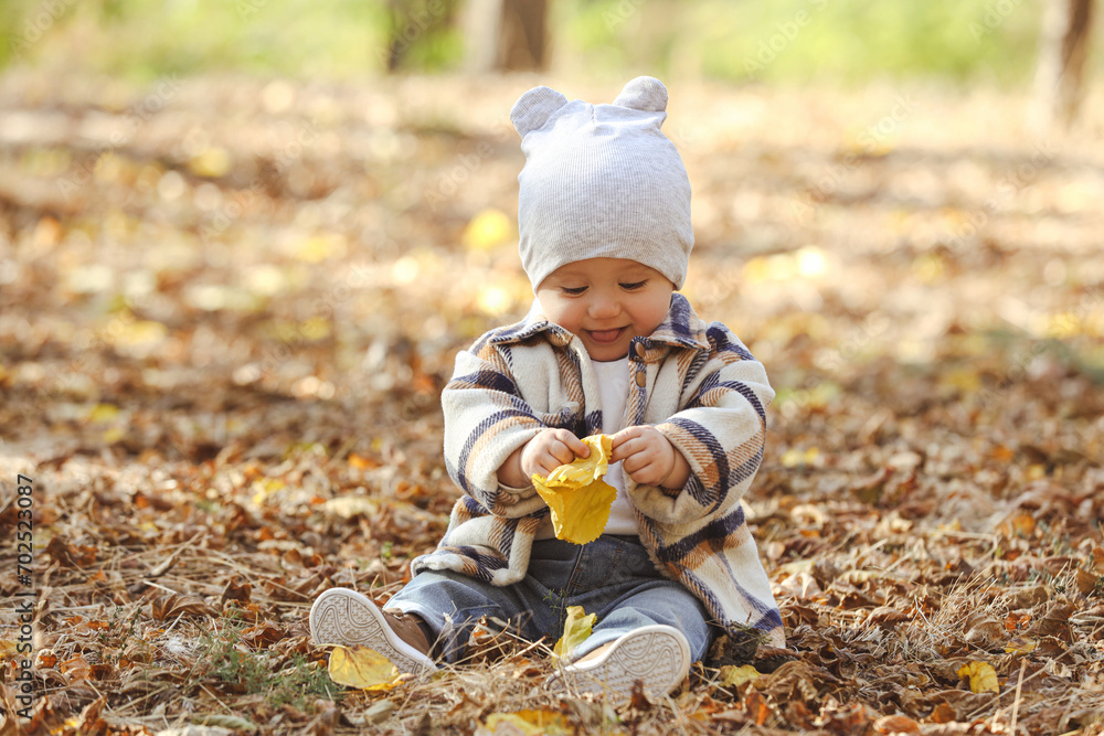 Cute little child on ground with dry leaves in autumn park Cute little child on ground with dry leaves in autumn park