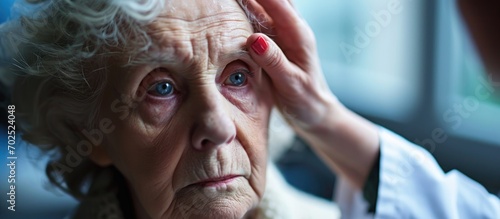 Senior lady has ailing eye closely examined. photo