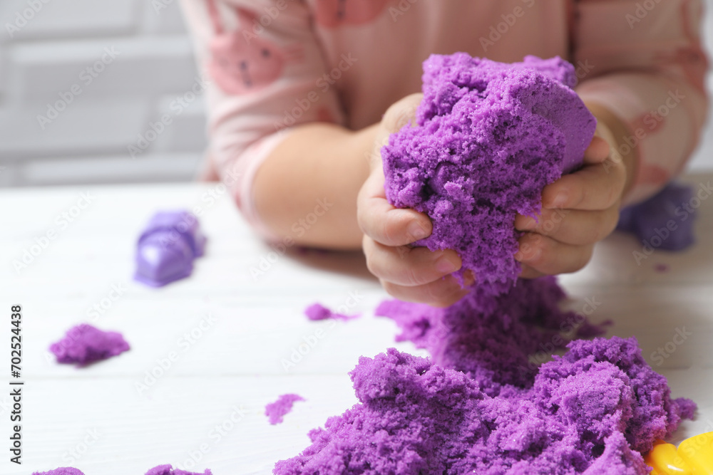 Little child playing with kinetic sand at white table, closeup Little child playing with kinetic sand at white table, closeup