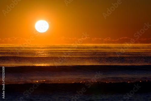 Atlantic Awakening  Majestic Sunrise Casting a Warm Orange Glow Over Misty Ocean Waves