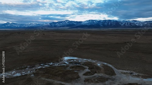 Snowy Mountains Seen From Meadow Hot Springs At Sunset In Fillmore, Millard County, Utah. aerial static shot, timelapse  photo