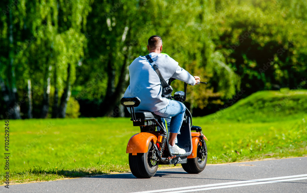 A man rolls on an electric scooter in the Park
