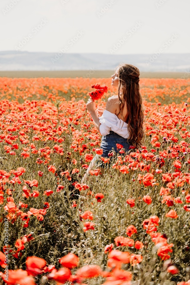 Woman poppies field. Side view of a happy woman with long hair in a poppy field and enjoying the beauty of nature in a warm summer day. Woman poppies field. Side view of a happy woman with long hair in a poppy field and enjoying the beauty of nature in a warm summer day.