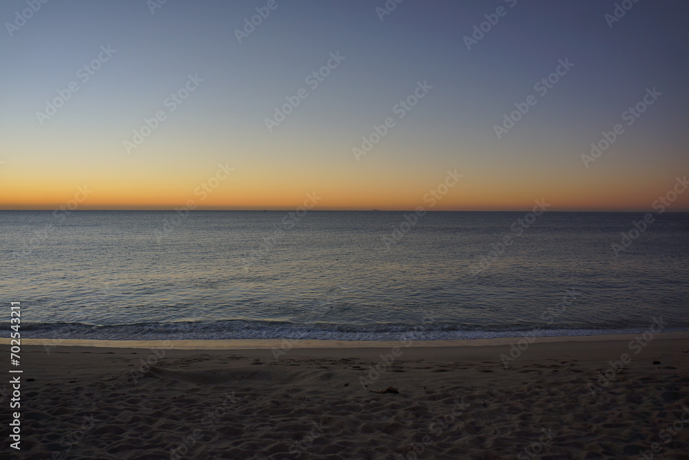 Naklejka premium Beach and ocean just before sunrise, sky turning bright