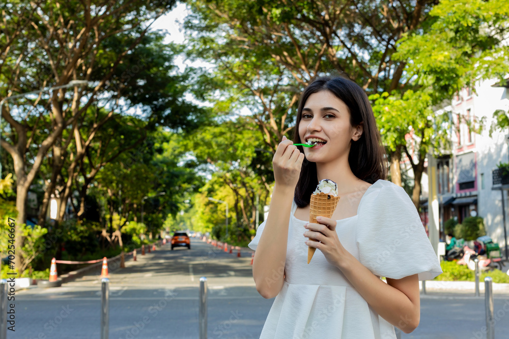 Beauty young woman eating an ice cream. Cheerful young women eating icecream. woman eat ice cream dessert in waffle cone at outdoor. Beauty young woman eating an ice cream. Cheerful young women eating icecream. woman eat ice cream dessert in waffle cone at outdoor.