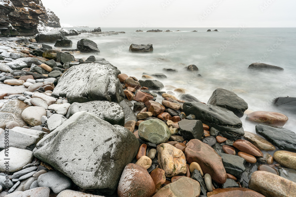 Rocky shores of the Varangerfjord on a cloudy and gray day during the polar night, Ekkerøya, Northern Norway